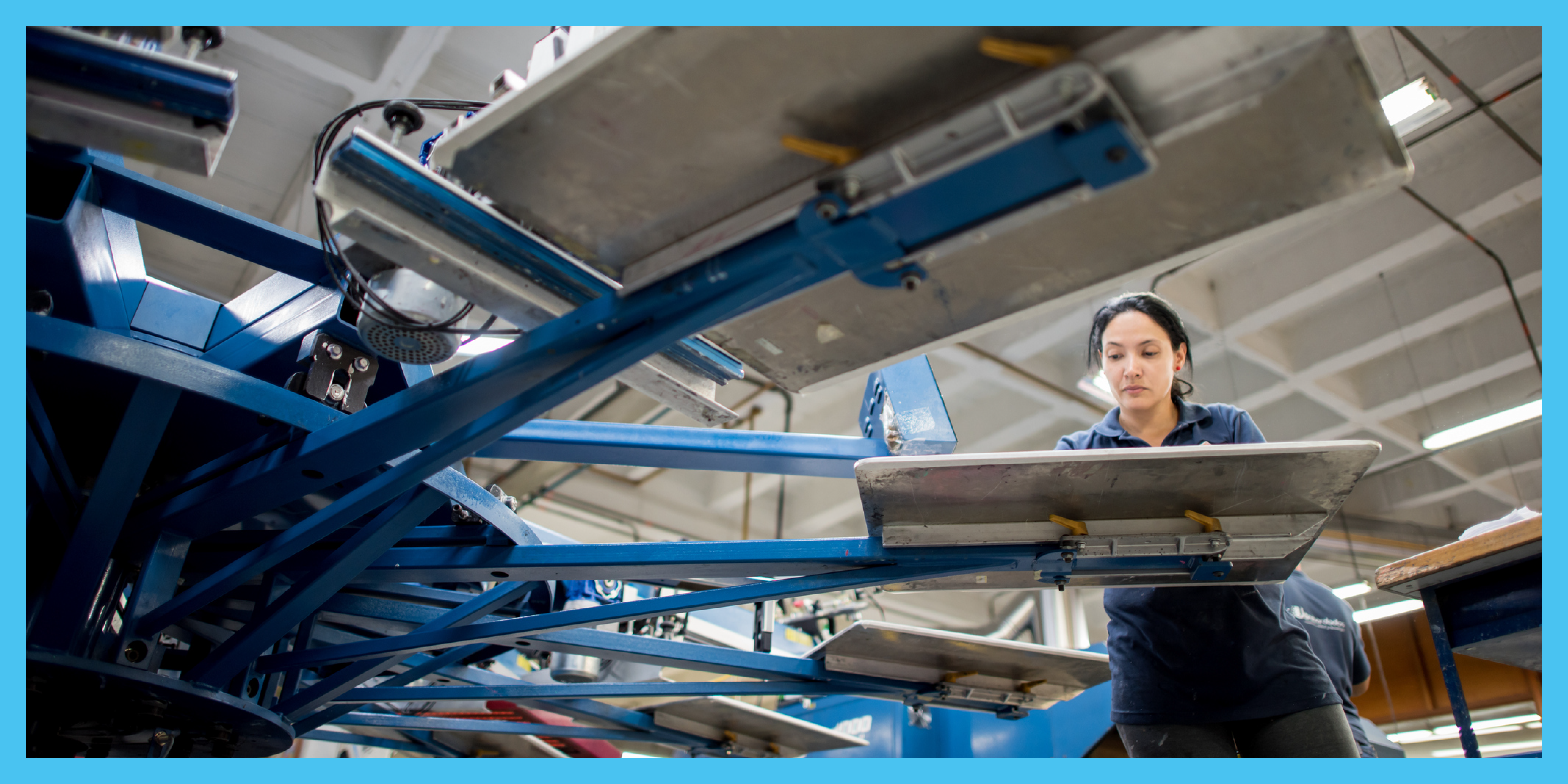 Woman using screen printer.