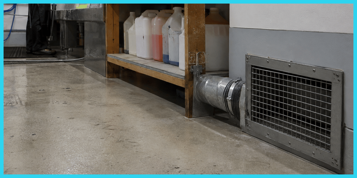 industrial-workspace-with-metal-ductwork-and-storage-shelves-containing-chemical-bottles