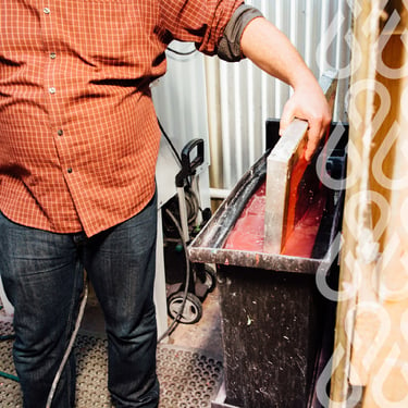 Person dipping screen into dip tank