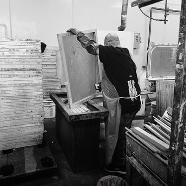 Man putting dirty screens into a dip tank screen cleaner