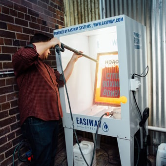 Man spraying a screen in Easiway washout booth 